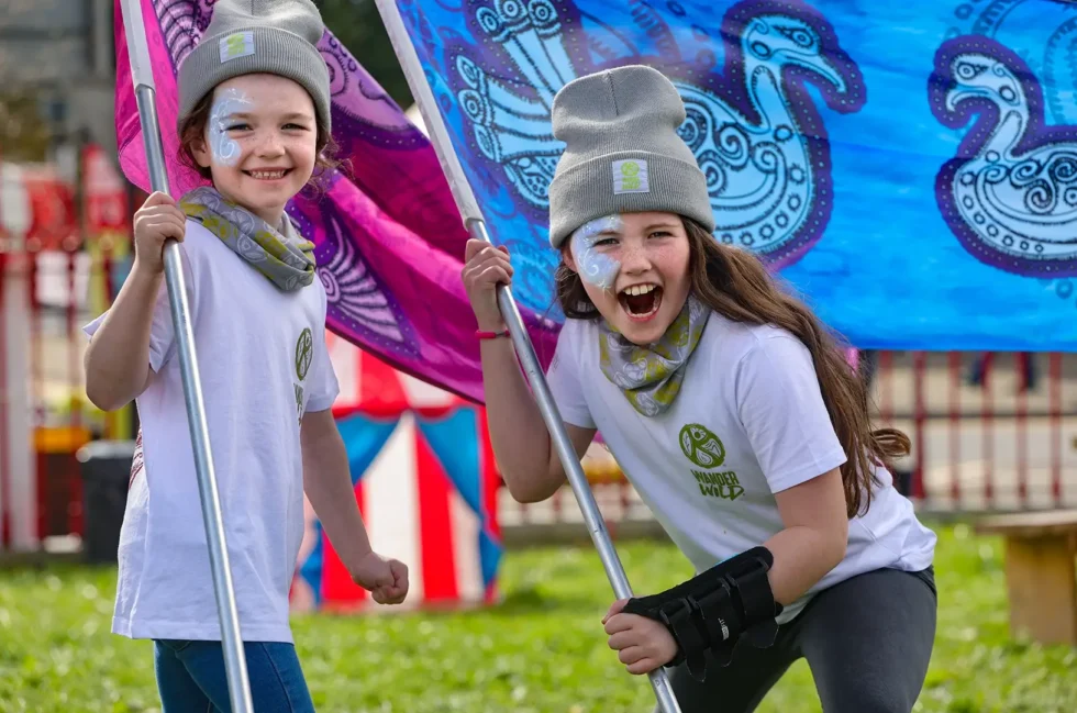 Wander Wild Festival Kids holding festival flags and wearing festival medrchandise