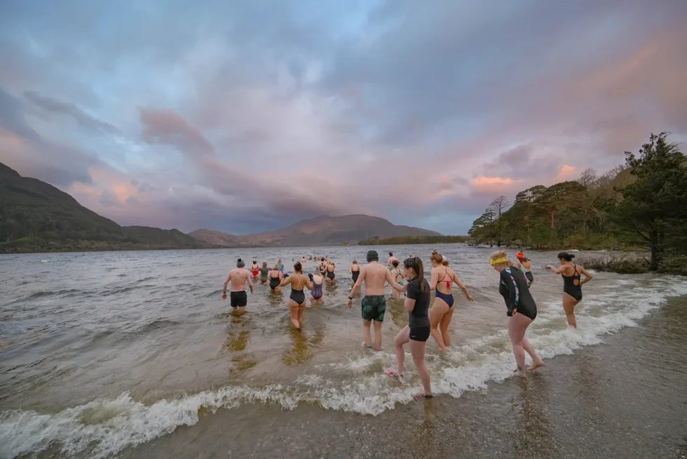 Wander Wild festival group heading into lake for Sunrise Dip