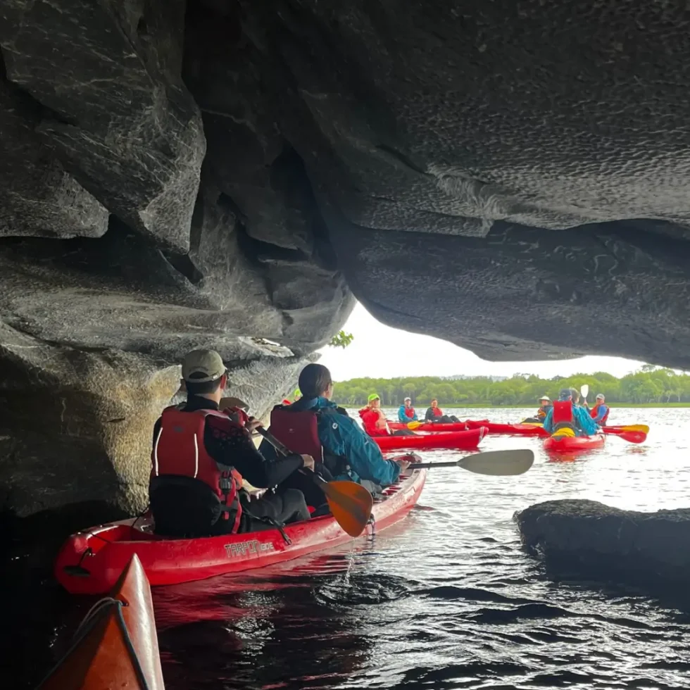 Kayakers kayaking through the limestone caves on Lough Leane