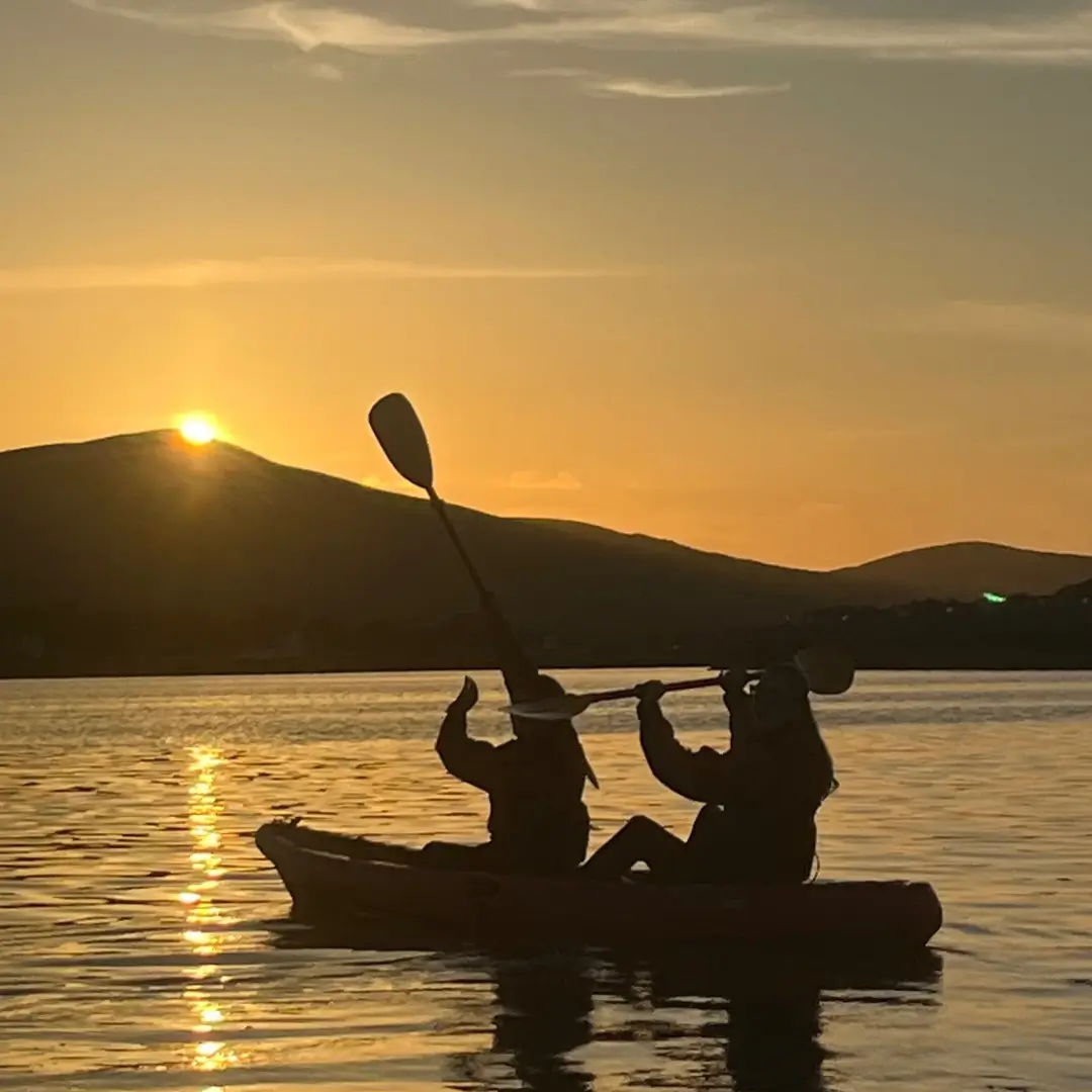 Two kayakers on the Lake kayaking into the sunset