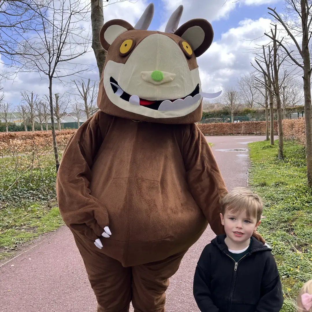 Gruffalo character standing with child