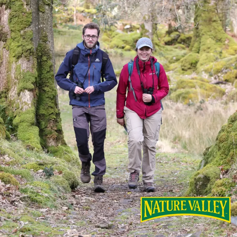 A couple walking in the woods with moss covered trees
