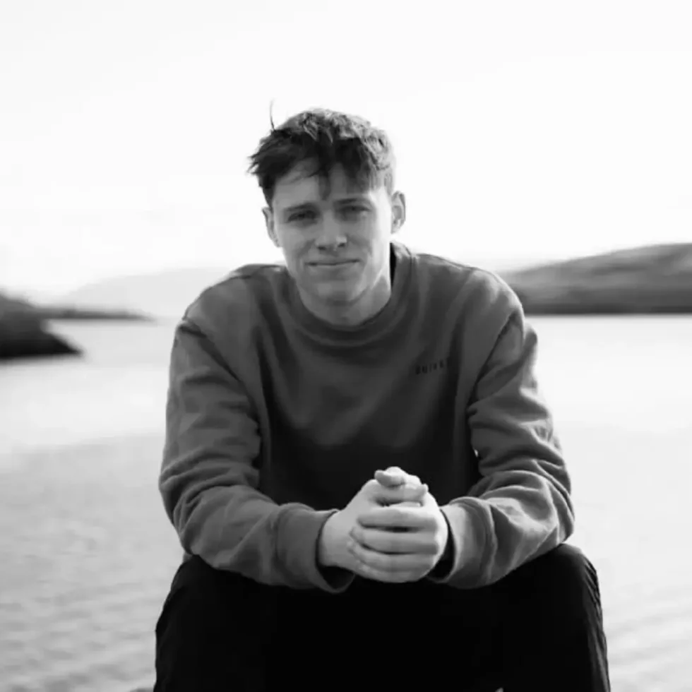 Caolan Ryan sitting outside in a black and white photo