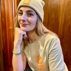 A lady posing with a wander wild beanie and tshirt