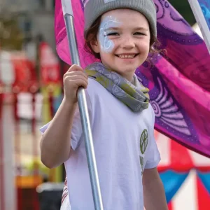A child holding a flag and smiling