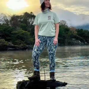 A lady standing in a lake wearing a sage wander wild tshirt