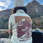A lady in a kayak wearing wander wild merchandise
