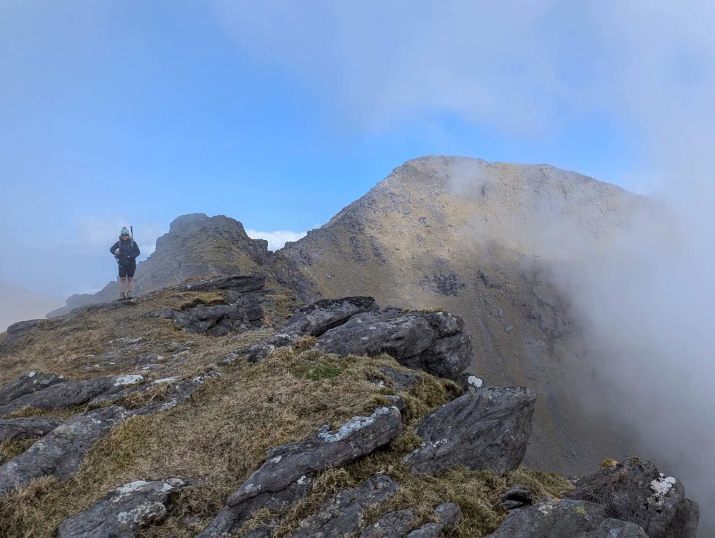 A hiker at the summit of a mountain in Killarney