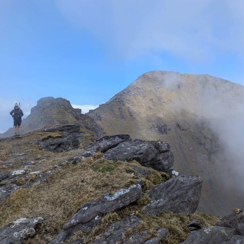 A hiker at the summit of a mountain in Killarney