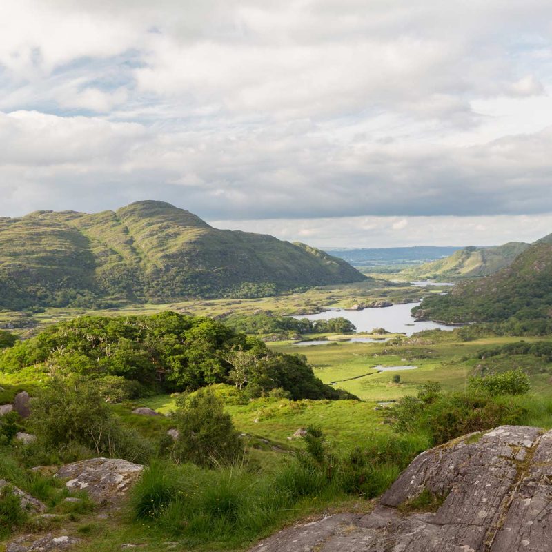 Golden sunlight cast over the rolling mountains and lakes of Killarney